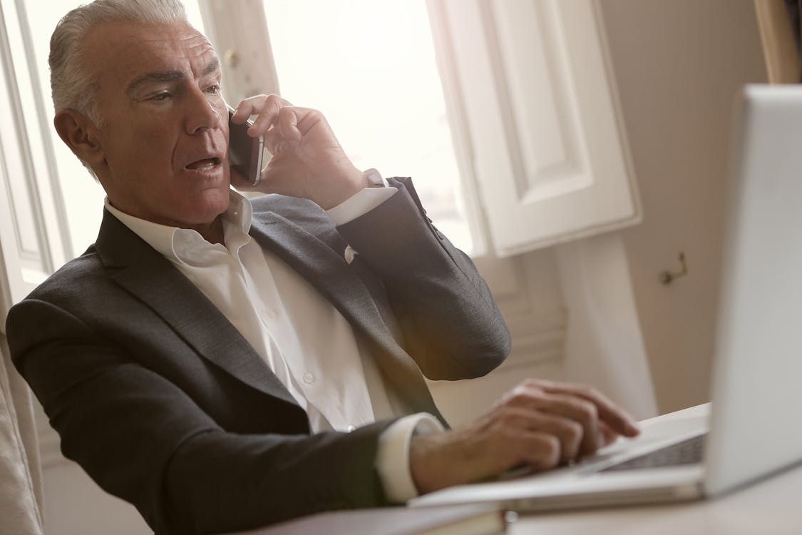 Free Man in Black Suit Jacket is Talking on the Phone Stock Photo