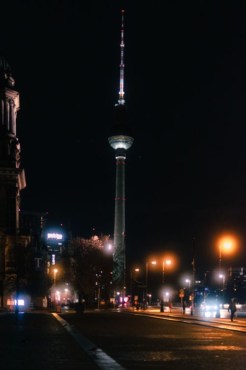 Free Night scene of Berlin's TV Tower glowing with city lights. Stock Photo