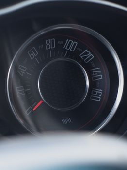 Close-up shot of a vintage car speedometer reading zero mph, evoking nostalgia.