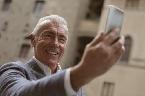 Man In Gray Suit Holding A Mobile Phone