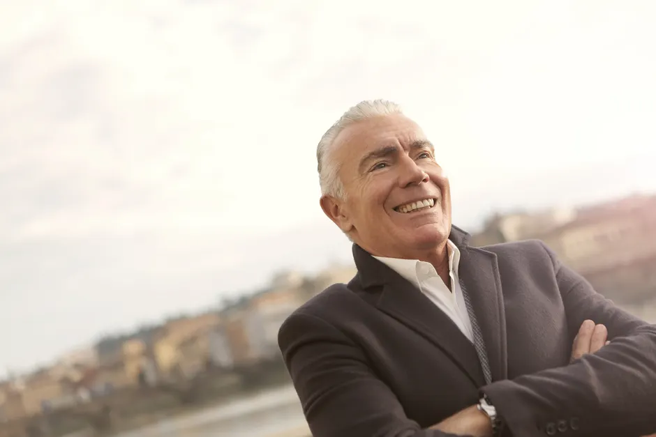 Un homme âgé souriant après avoir amélioré son audition grâce à Europe Audition.