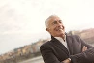 一位身着职业装的男士在明媚的阳光下自信地微笑着