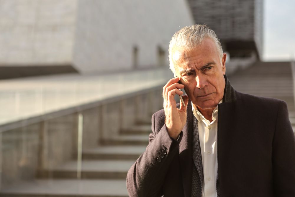 A professional man looking concerned while checking his phone