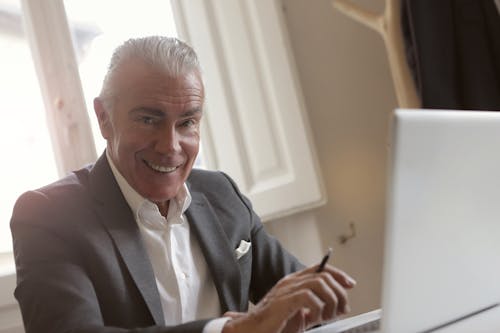 Free Man In Gray Suit Holding Pen Stock Photo