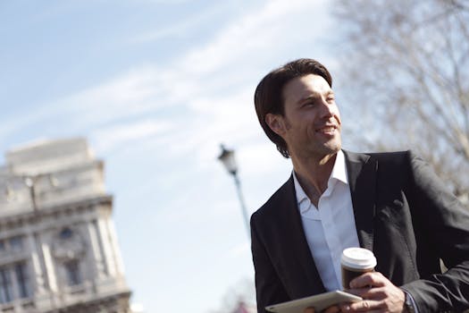 在城市环境中，商人手持平板电脑，品味咖啡，散发着自信与现代感