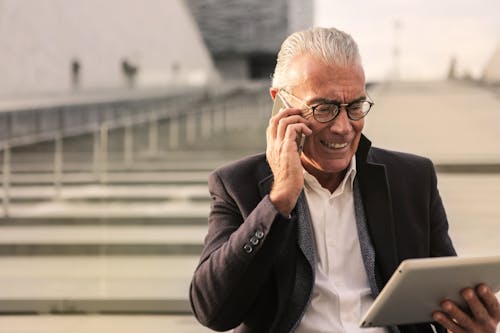 Executivo sénior usando tecnologia ao ar livre