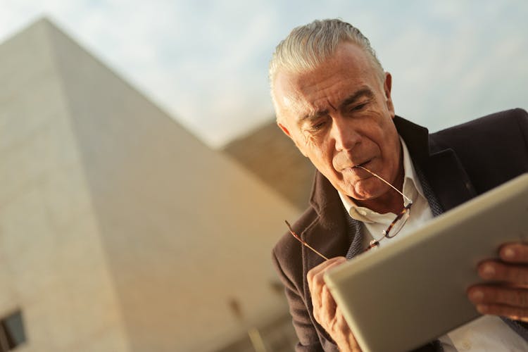 A Sad Man Using Silver Tablet