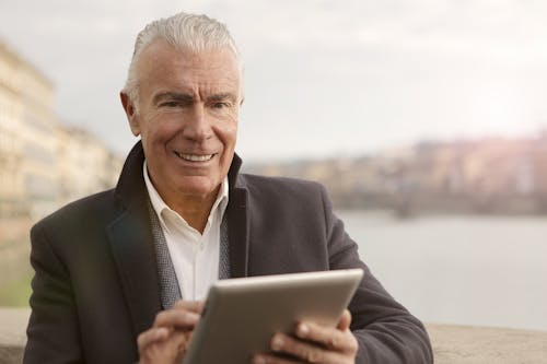 Man In Black Suit Holding A Gadget