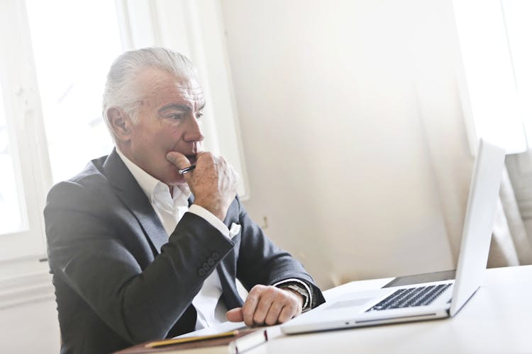 Pensive Man Leaning On White Table