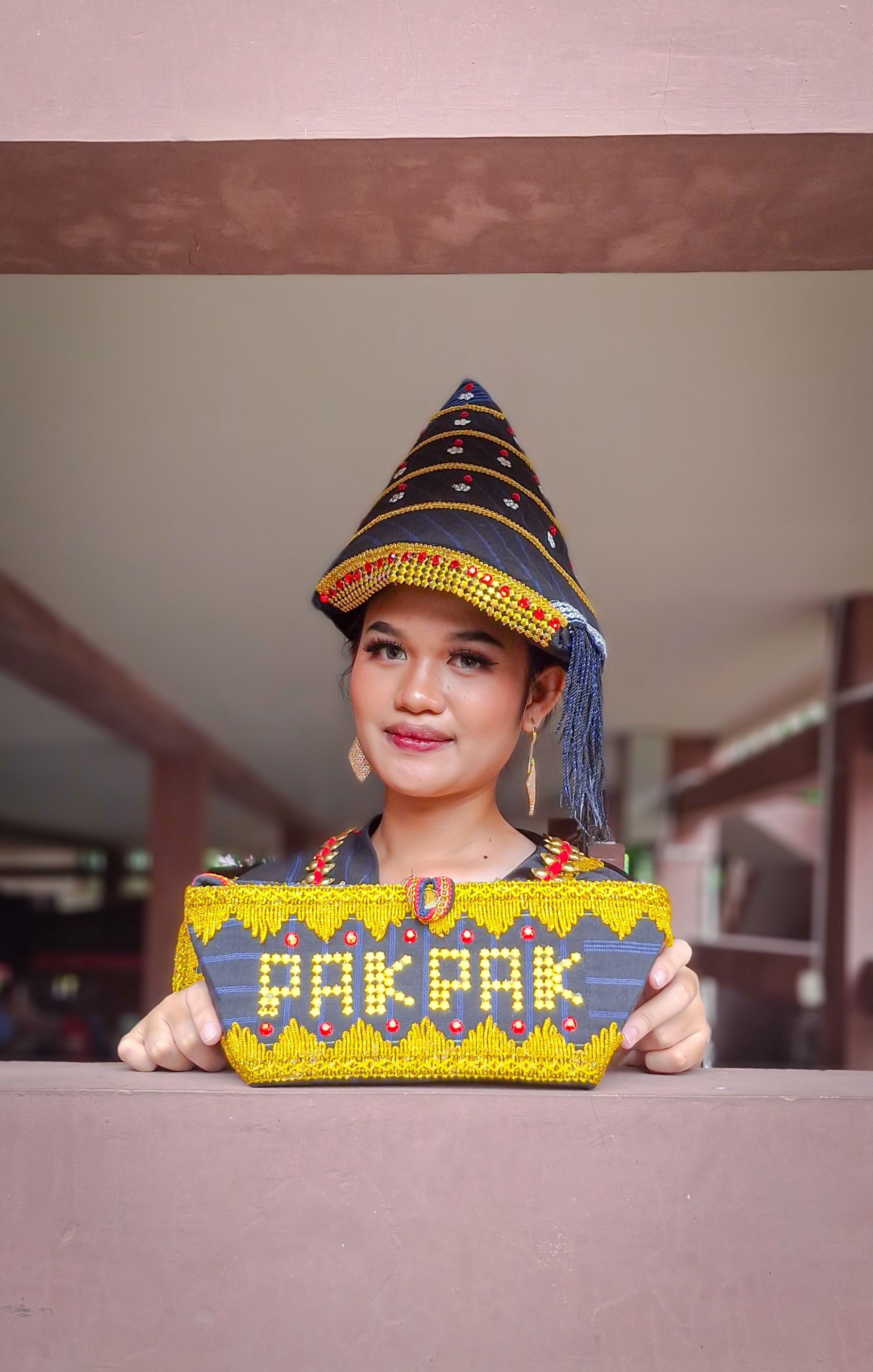 Young woman in traditional attire with Pakpak text, Daerah Khusus Ibukota Jakarta.