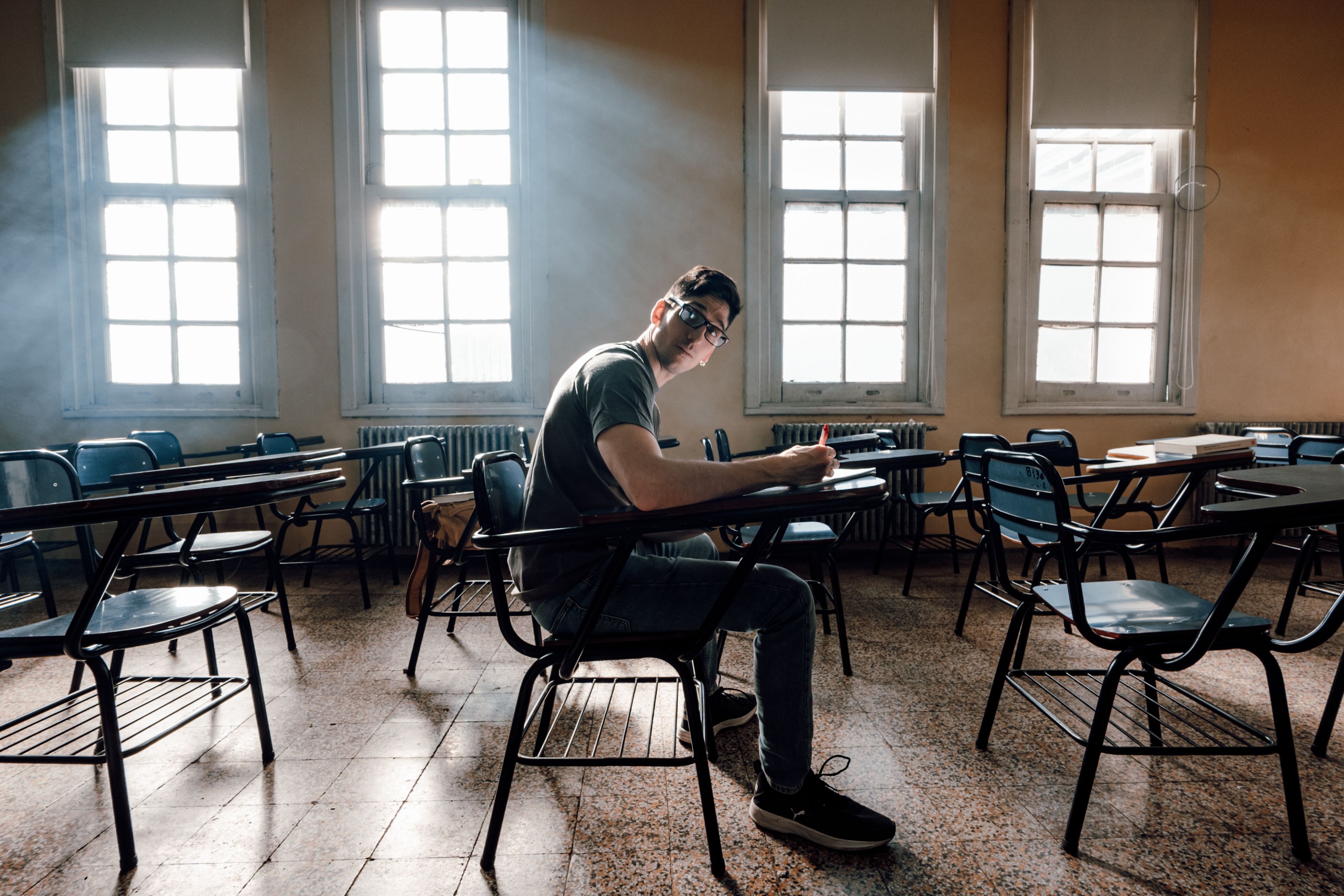 A student studies alone in a sunlit classroom in Buenos Aires, Argentina.