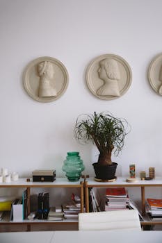精致的办公室室内装饰，通过半身像艺术、充满活力的植物和井然有序的架子，营造出现代艺术氛围