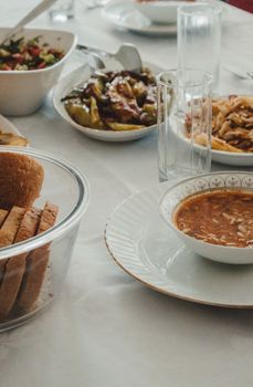 Close-up of a table with diverse dishes including soup, salad, and bread, perfect for a communal meal.