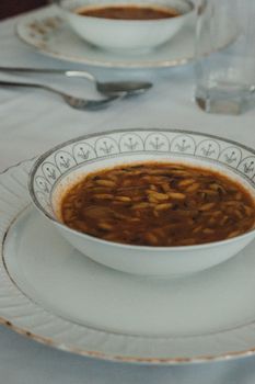 A refined image of a soup bowl on an elegant table setting with fine china.