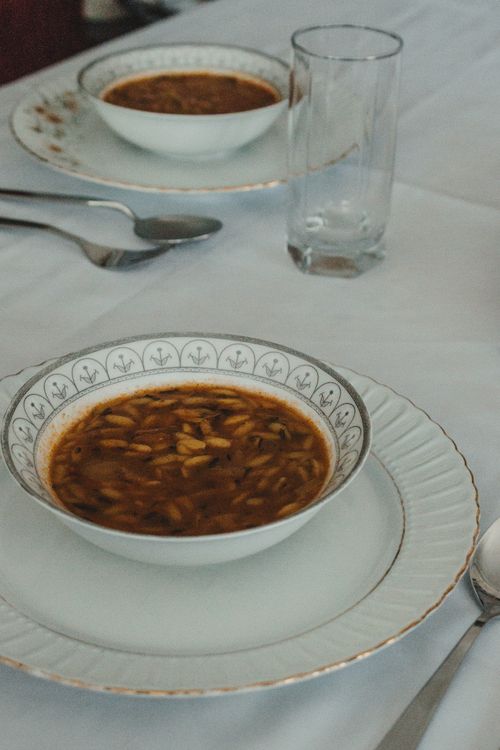 Free A stylish table setting featuring soup in decorative china bowls on a white tablecloth. Stock Photo
