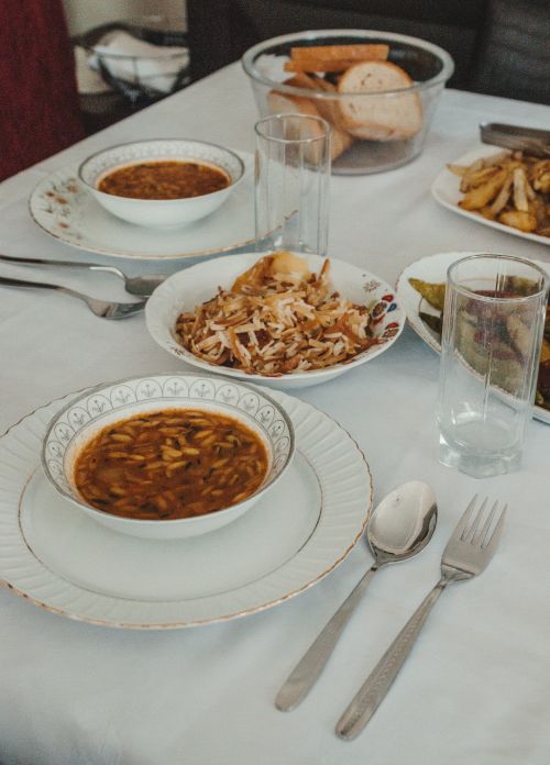 Shared table of soup and bread by İdil Ceren Çelikler on Pexels