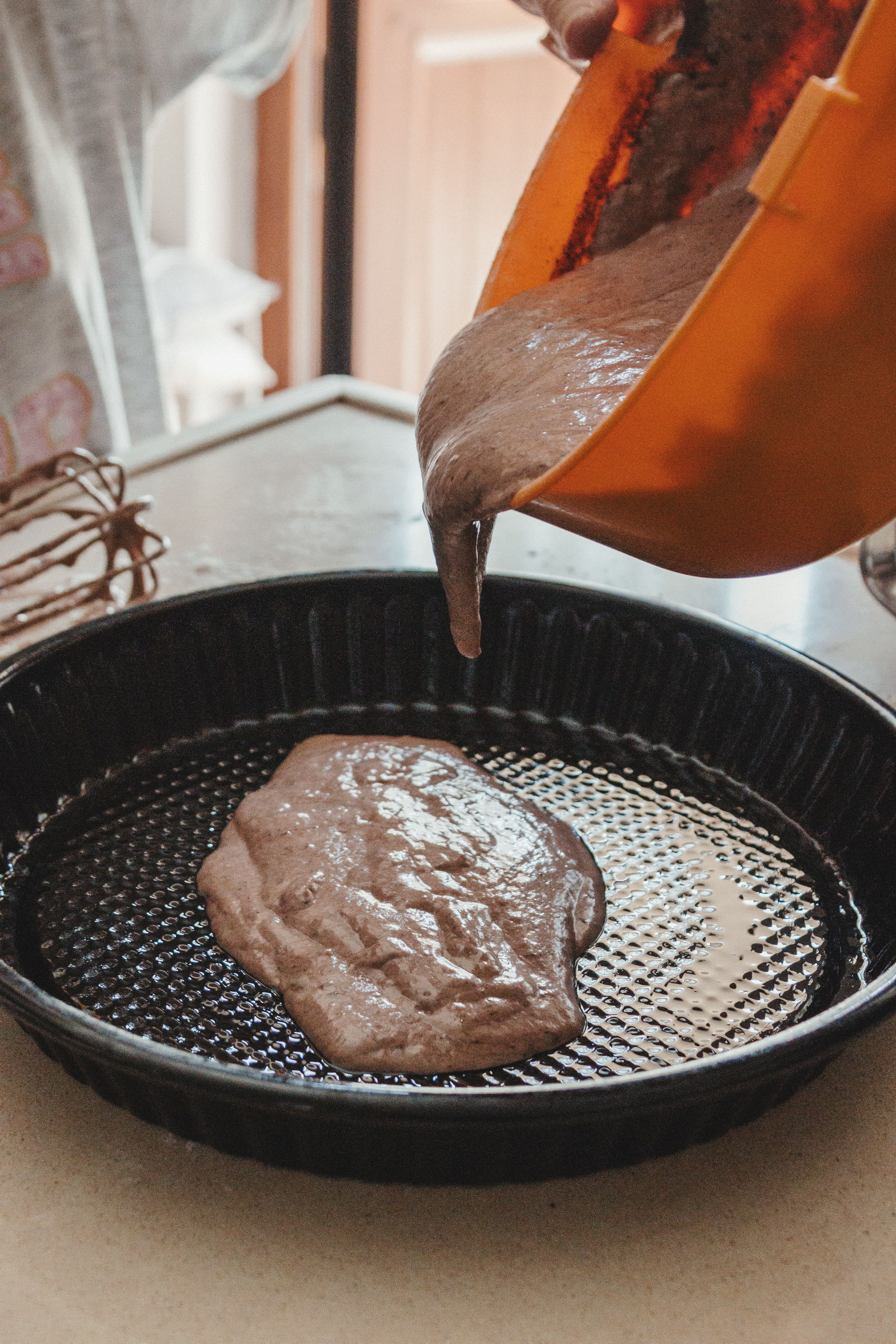 Pouring Chocolate Cake Batter into Baking Pan · Free Stock Photo