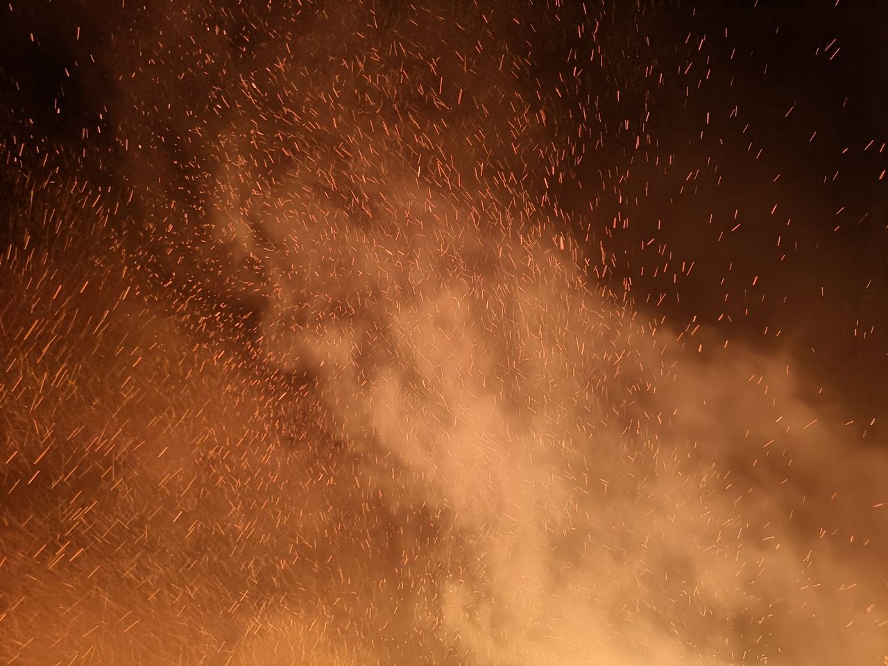 a captivating image of fire sparks and smoke filling the night sky cre