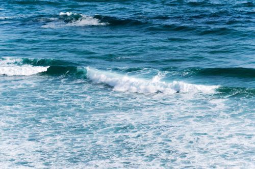 Free Dynamic ocean waves crashing against the coastal waters of Ireland under clear skies. Stock Photo