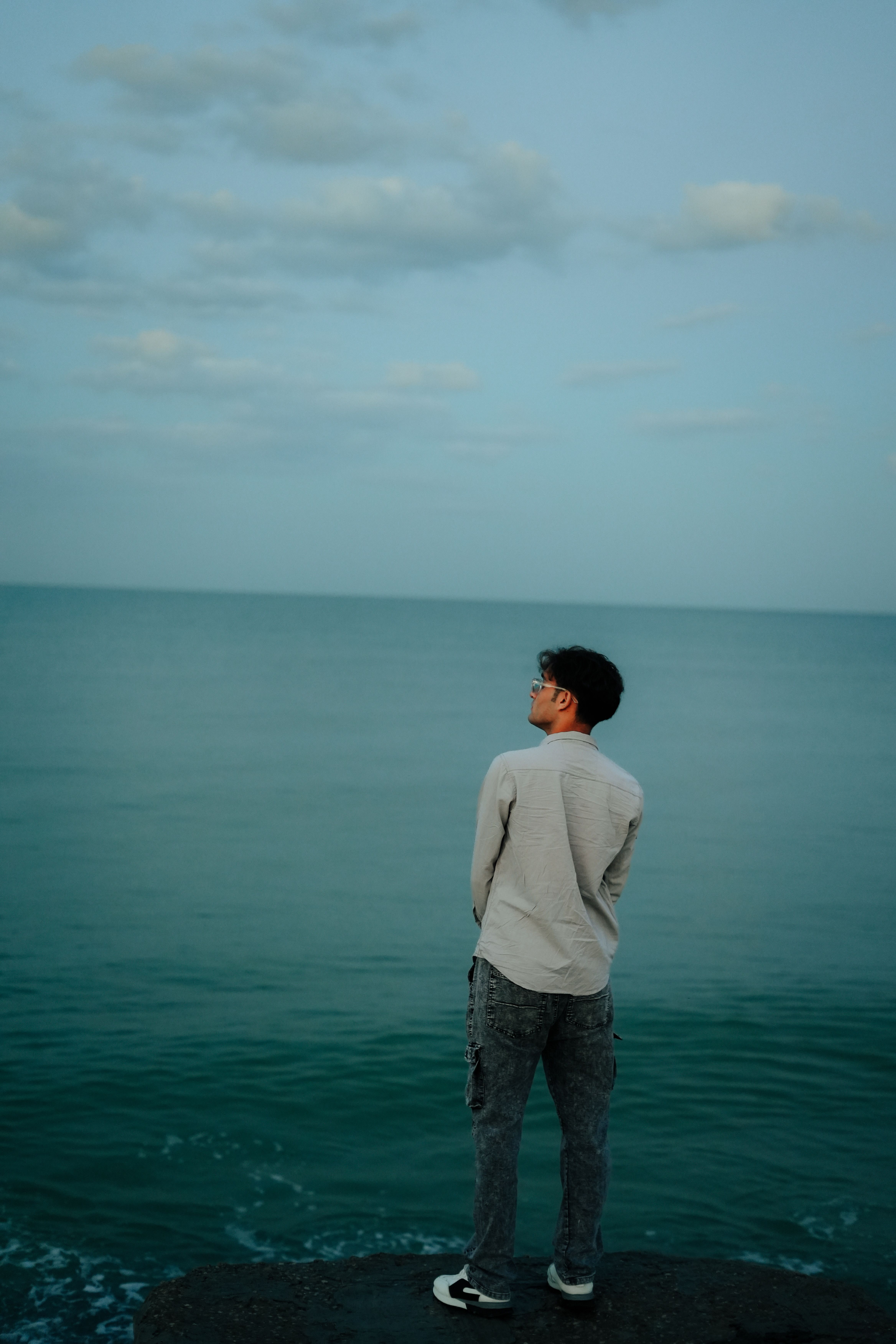 Man Standing on Rocky Shore at Sunrise · Free Stock Photo