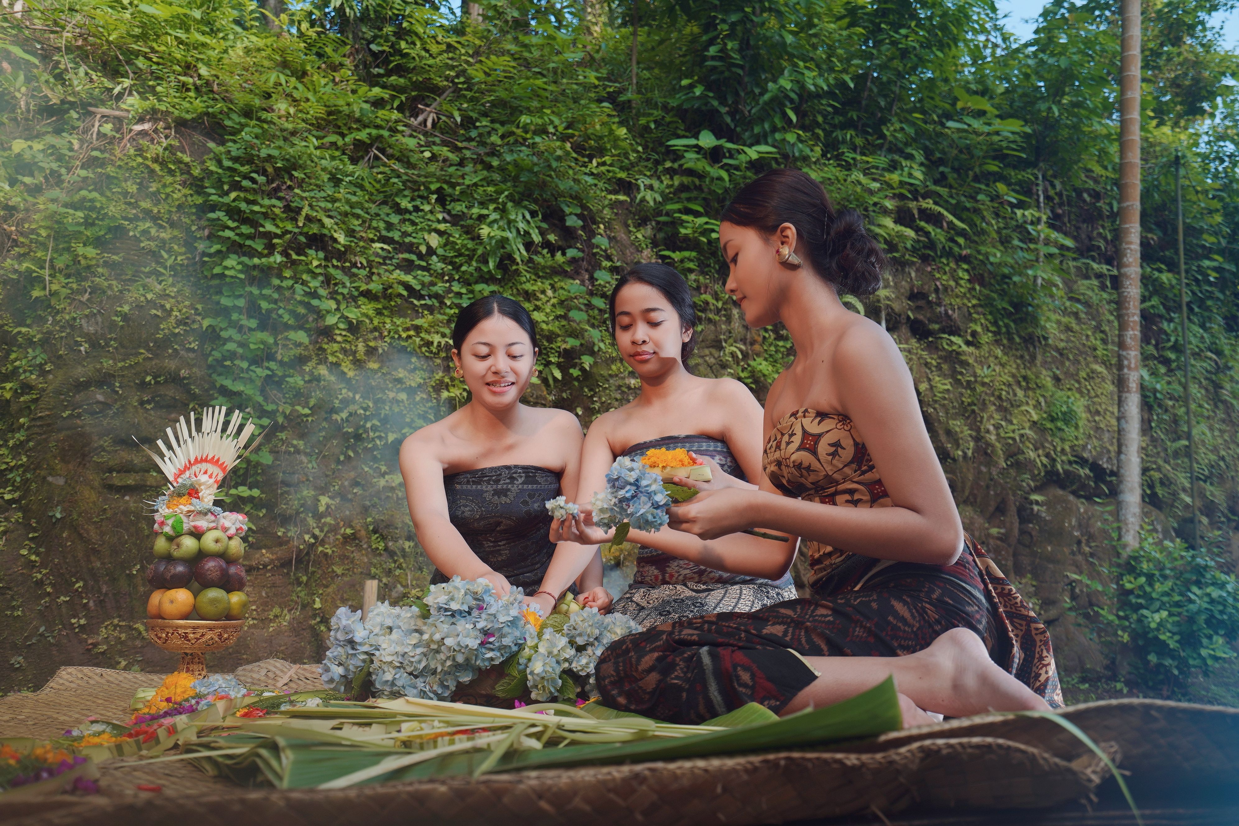 Balinese villagers arranging a traditional cockfight arena, woven bamboo barriers and solemn ceremonial preparations