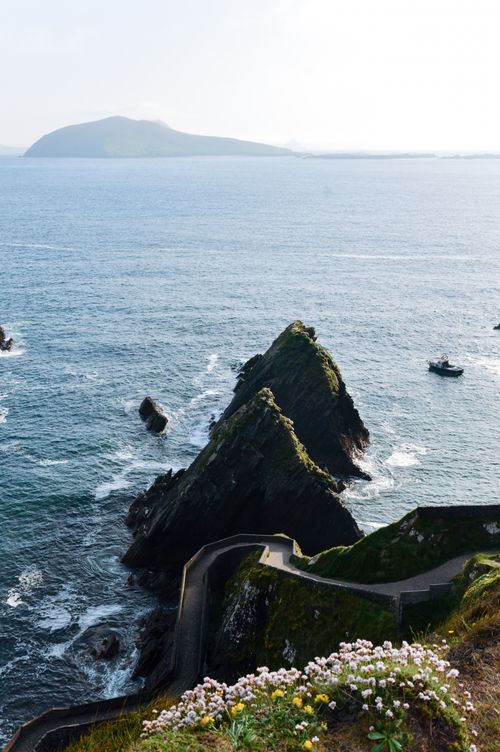 Free Breathtaking view of Dunquin Pier, Dingle Peninsula with dramatic rocky cliffs meeting the ocean. Stock Photo