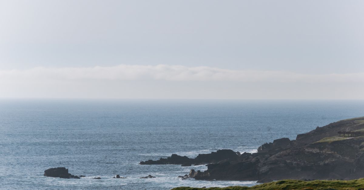 A tranquil coastal scene in Ireland showcasing cliffs and the Atlantic Ocean.