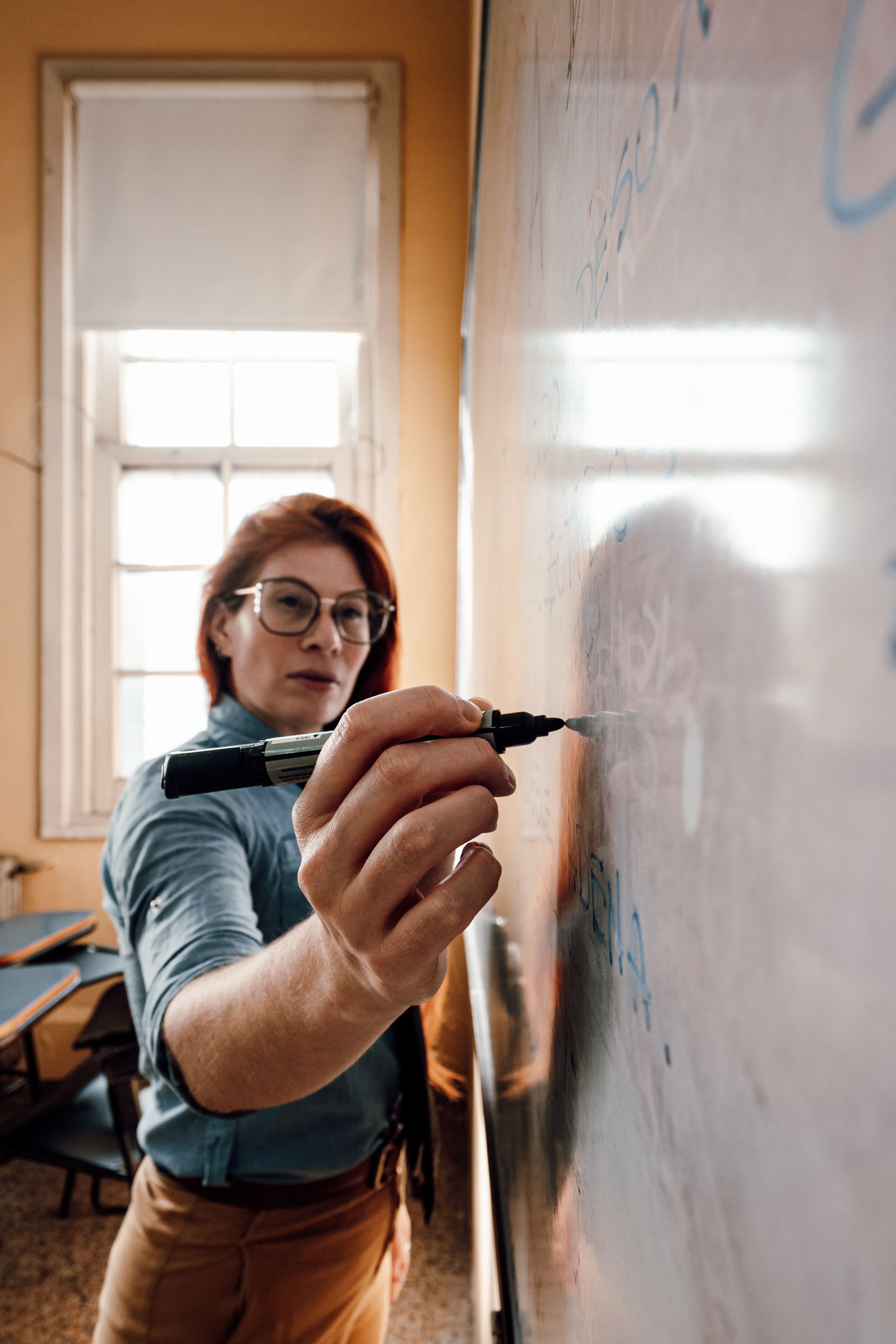 A dedicated teacher in Buenos Aires explains concepts on the classroom whiteboard.