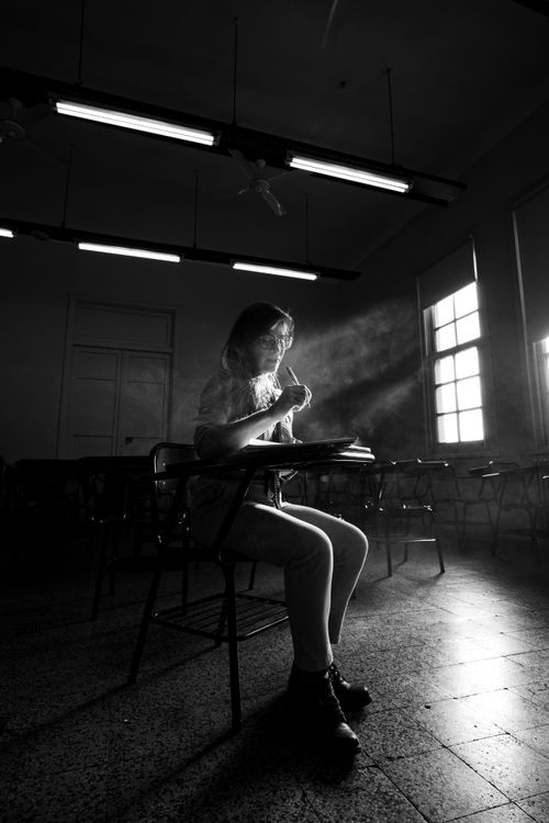 Free A student reading in a starkly lit classroom in Buenos Aires. Stock Photo