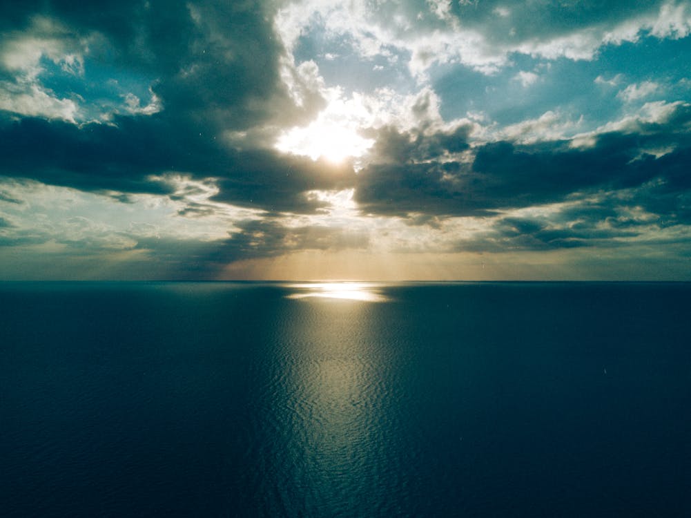 Free Ocean Under Crepuscular Clouds Stock Photo