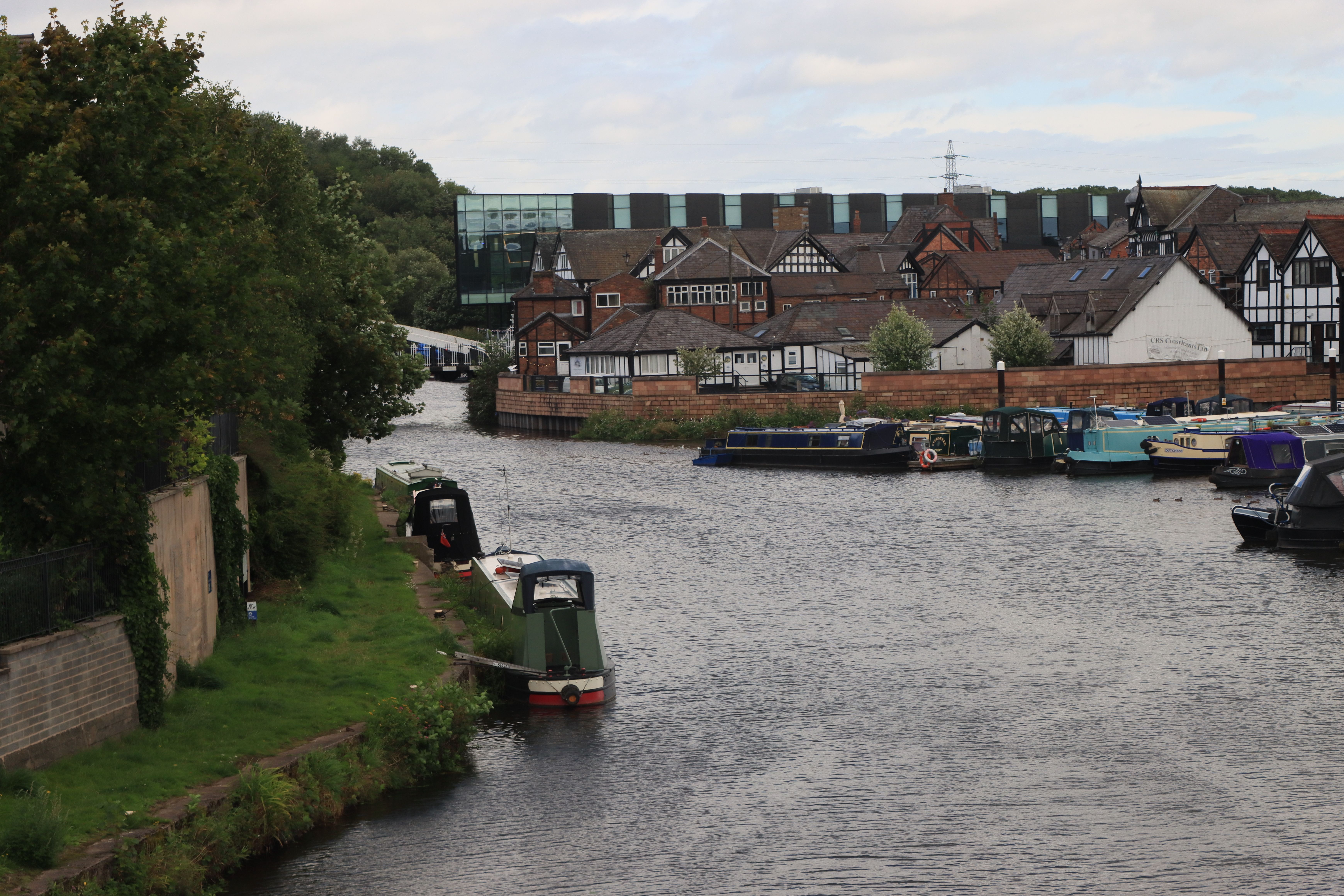 Scenic view of the canal and historic buildings in Northwich, England. Tranquil waterway with boats and Tudor architecture.