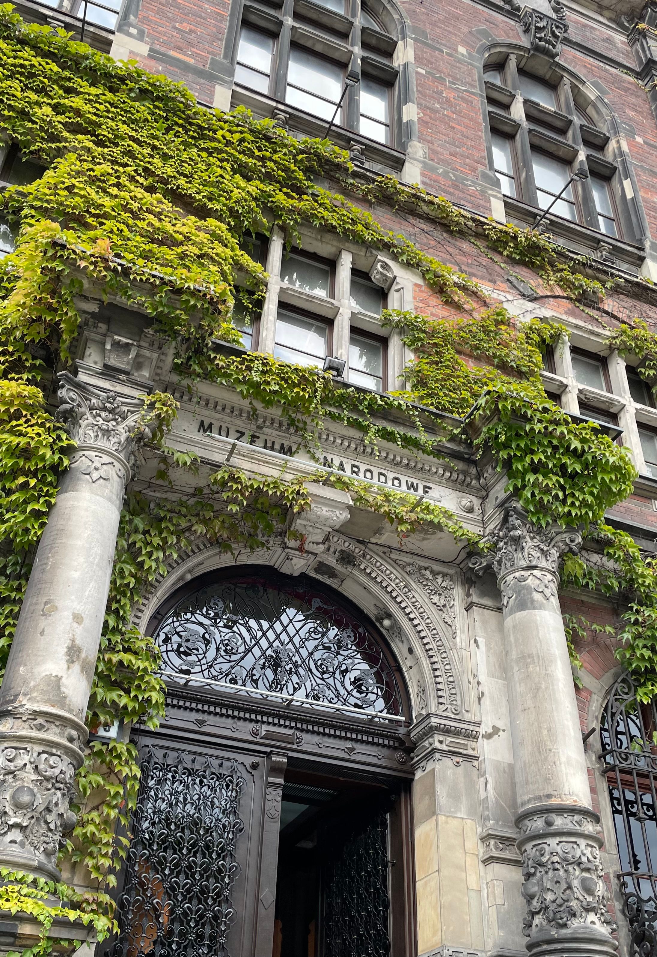 Ivy-covered entrance of the National Museum in Wroclaw, showcasing intricate architectural details.
