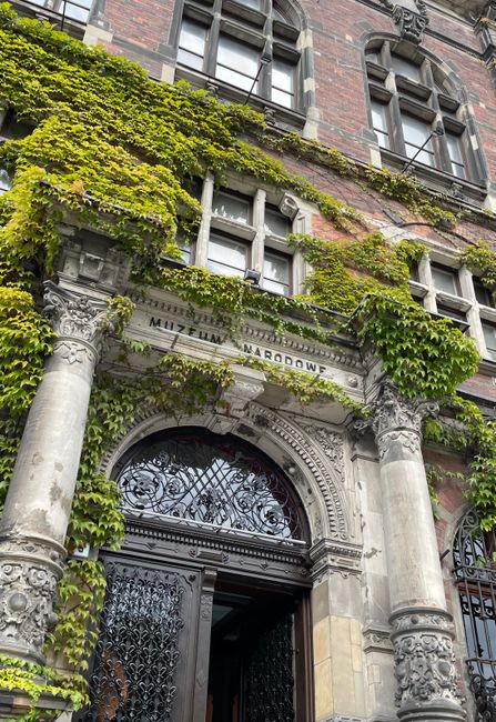 Ivy-covered entrance of the National Museum in Wroclaw, showcasing intricate architectural details.