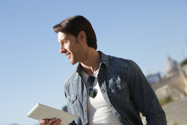 Man In Blue Polo Shirt Holding White Tablet