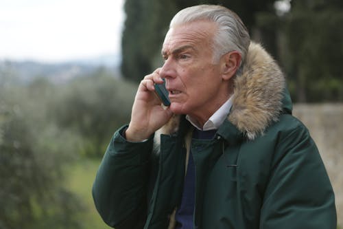 Man in Green Jacket Holding Phone