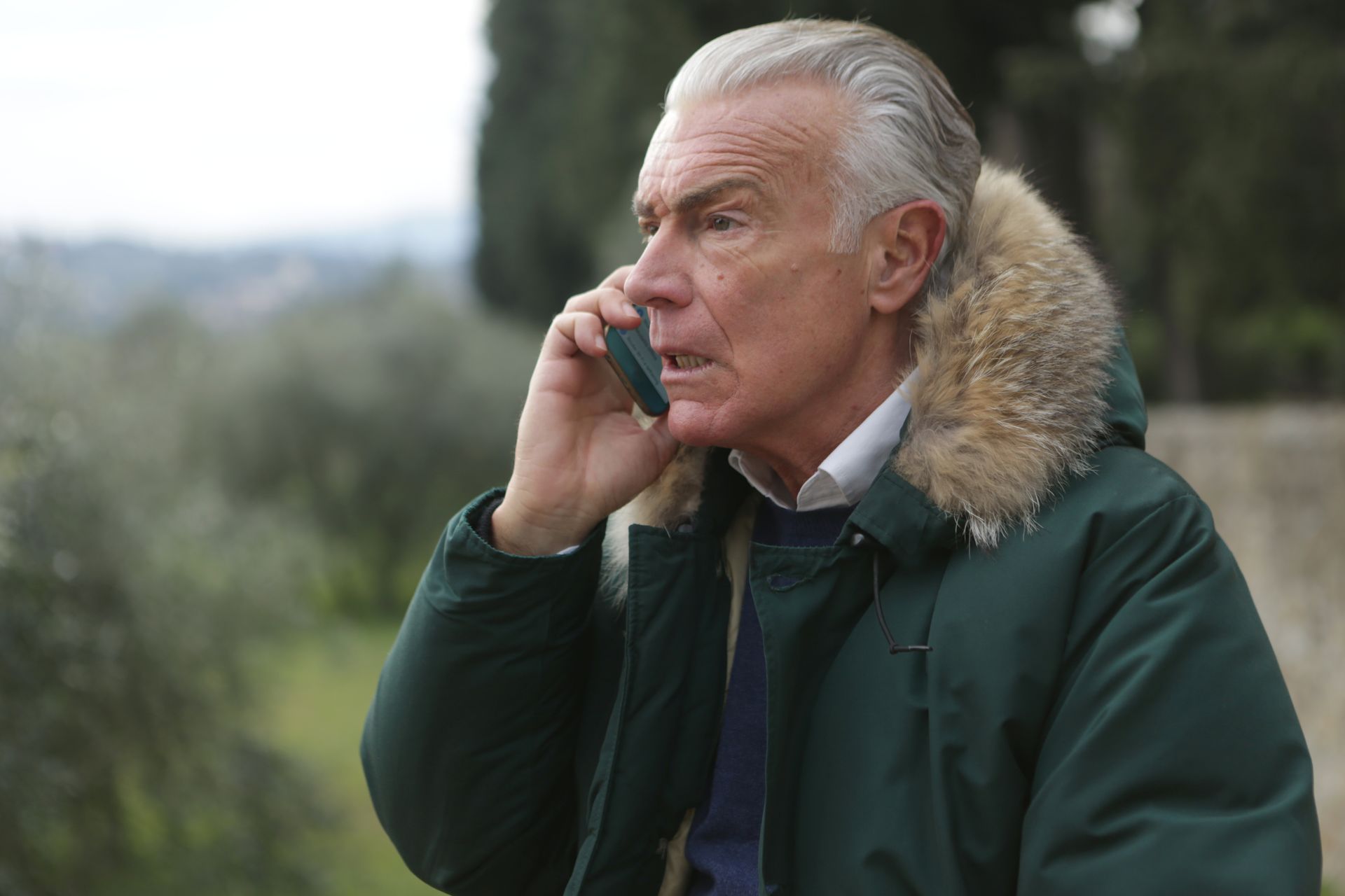 Man in Green Jacket Holding Phone