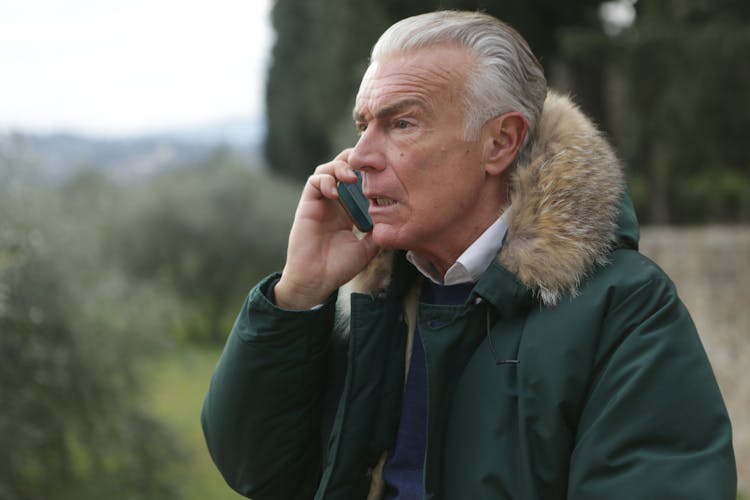 Man In Green Jacket Holding Phone