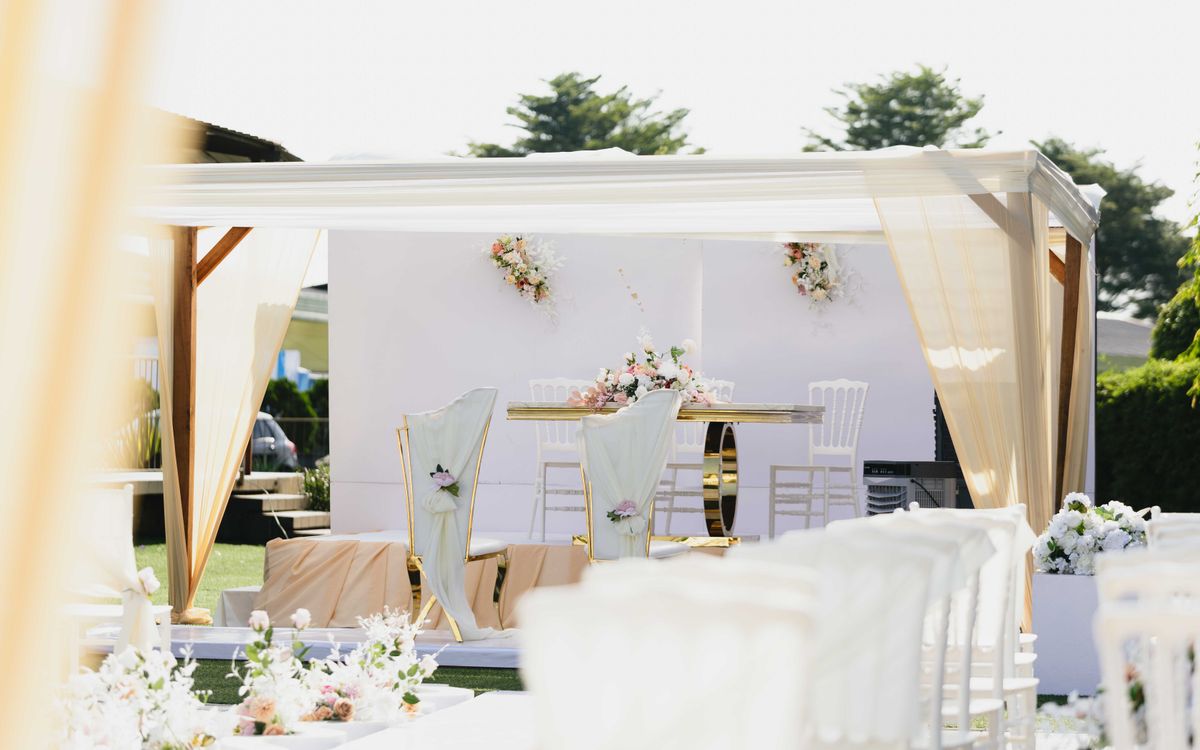 Beautiful outdoor wedding ceremony setting with white and pastel-colored decor and floral arrangements.