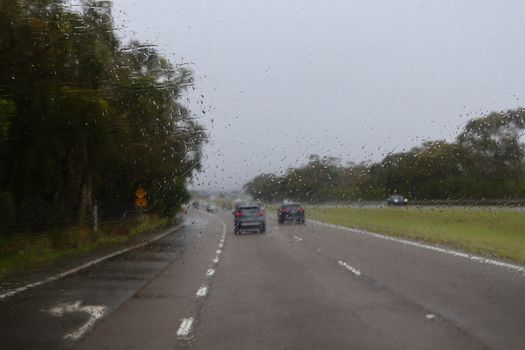 A blurred highway view during a rainy day drive in NSW, Australia, capturing nature and road travel.