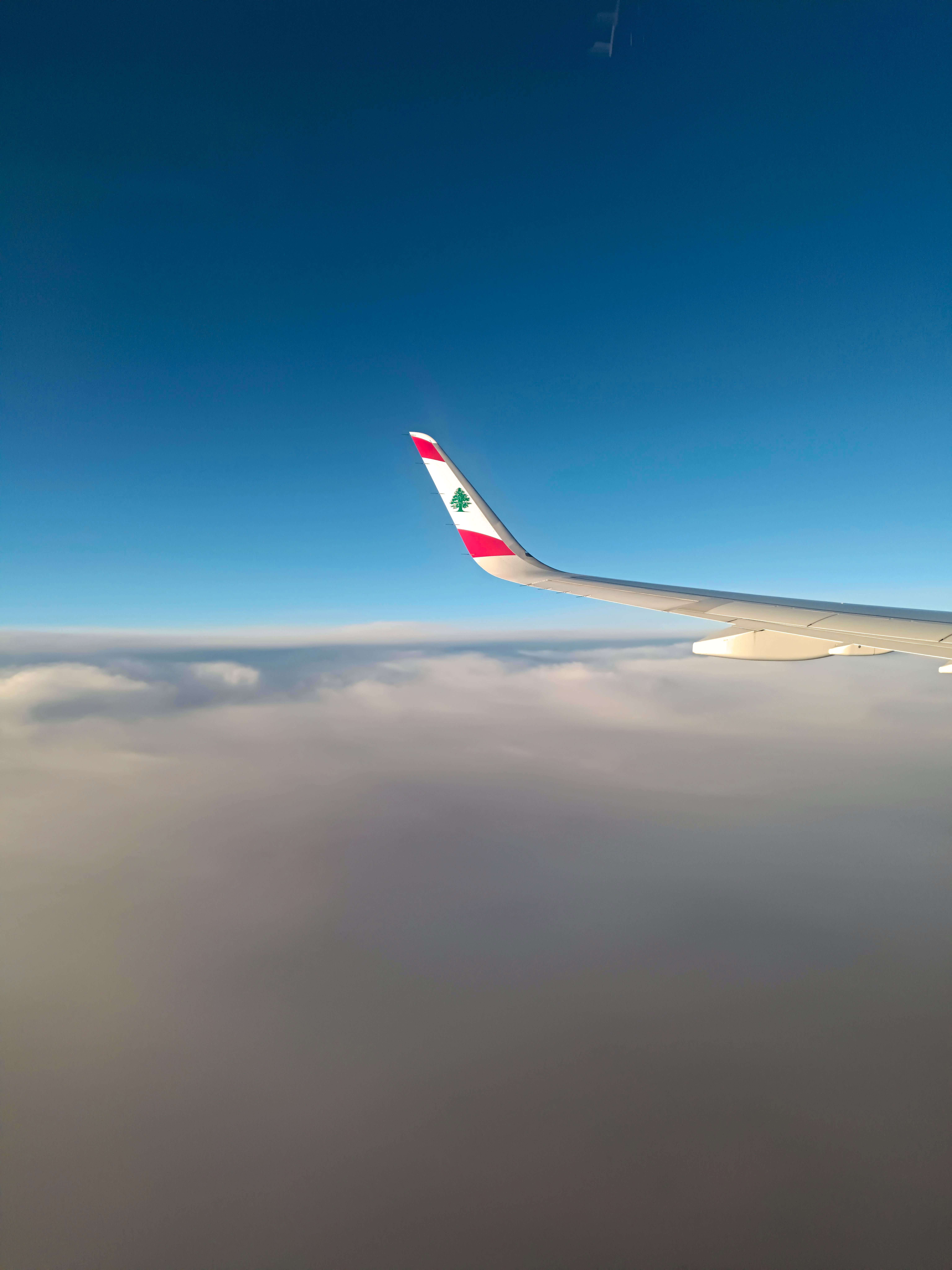 Gratuit Aripă de avion cu steag libanez pe fundalul unui cer albastru senin și al norilor. Fotografie de stoc
