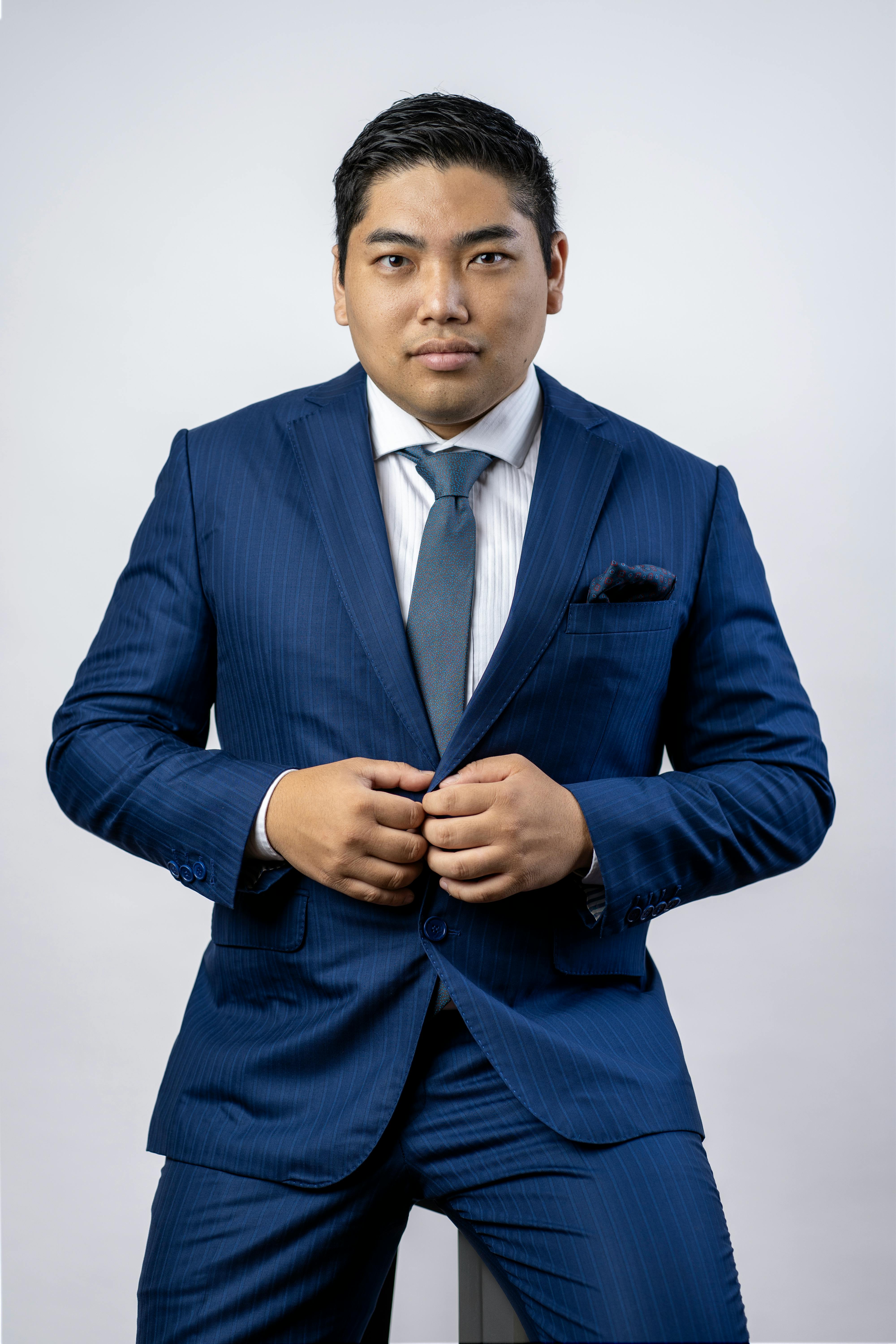 Portrait of a confident businessman wearing a blue suit, looking directly at the camera.