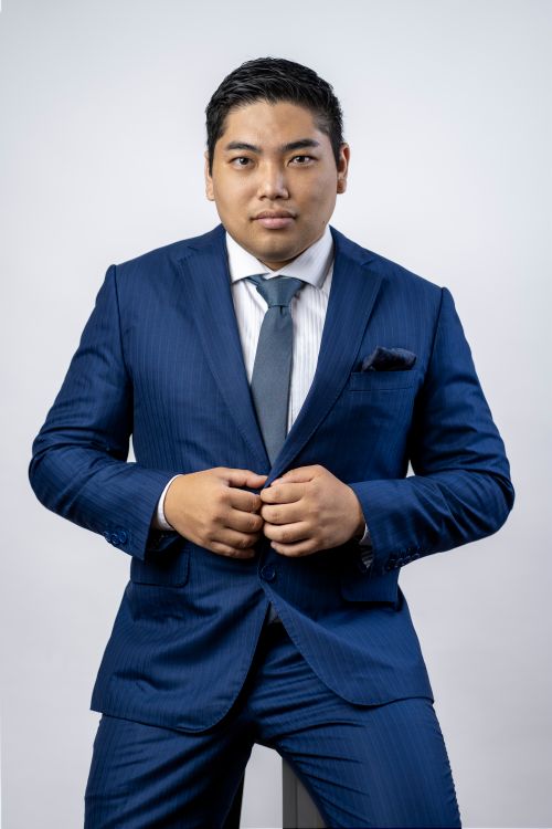 Free Portrait of a confident businessman wearing a blue suit, looking directly at the camera. Stock Photo