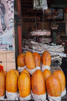 Ripe papayas stacked outside a market stall in Ciudad de México, showcasing vibrant tropical fruits.