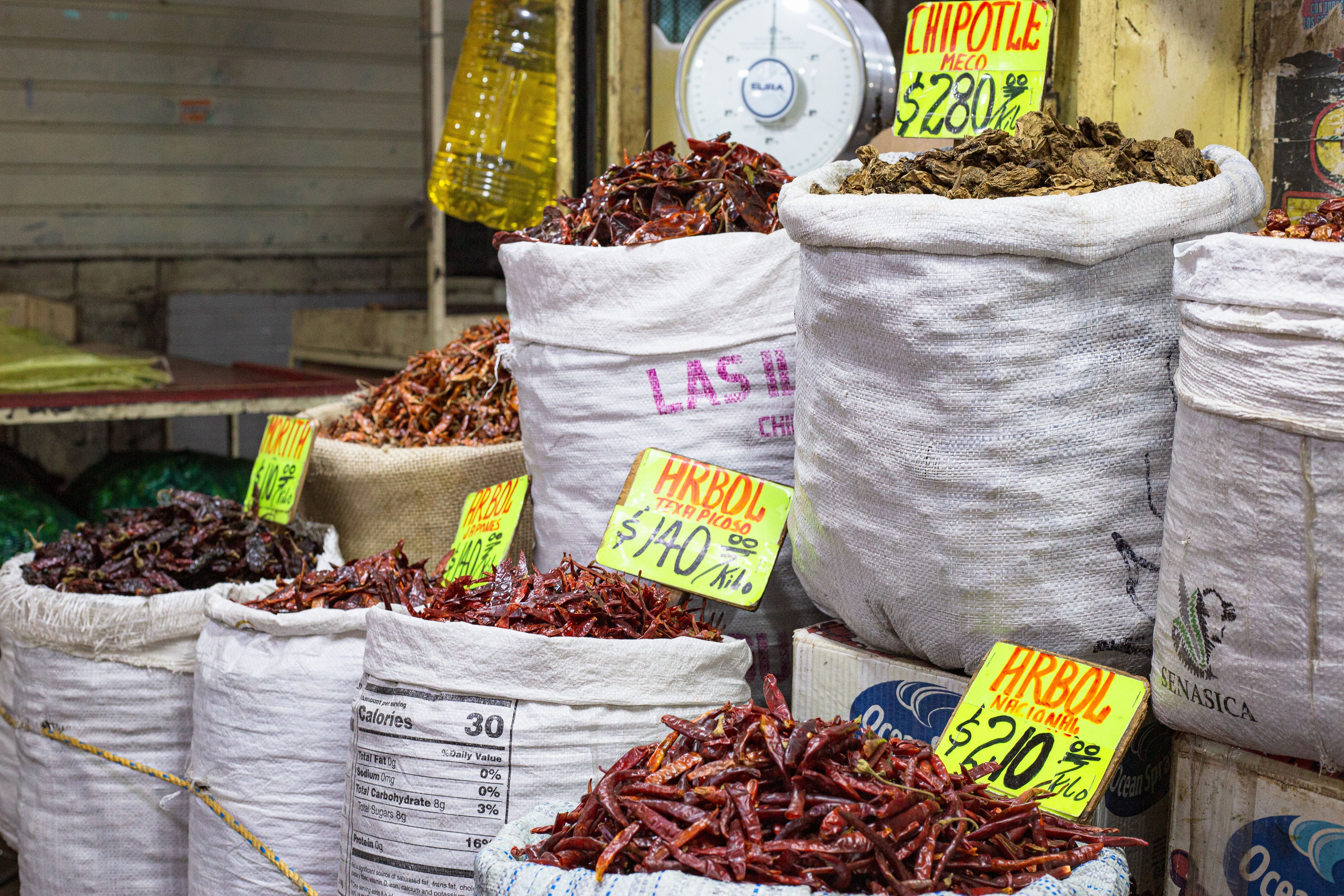 Bags of dried chilies for sale at a market in Mexico City, showcasing a colorful variety.