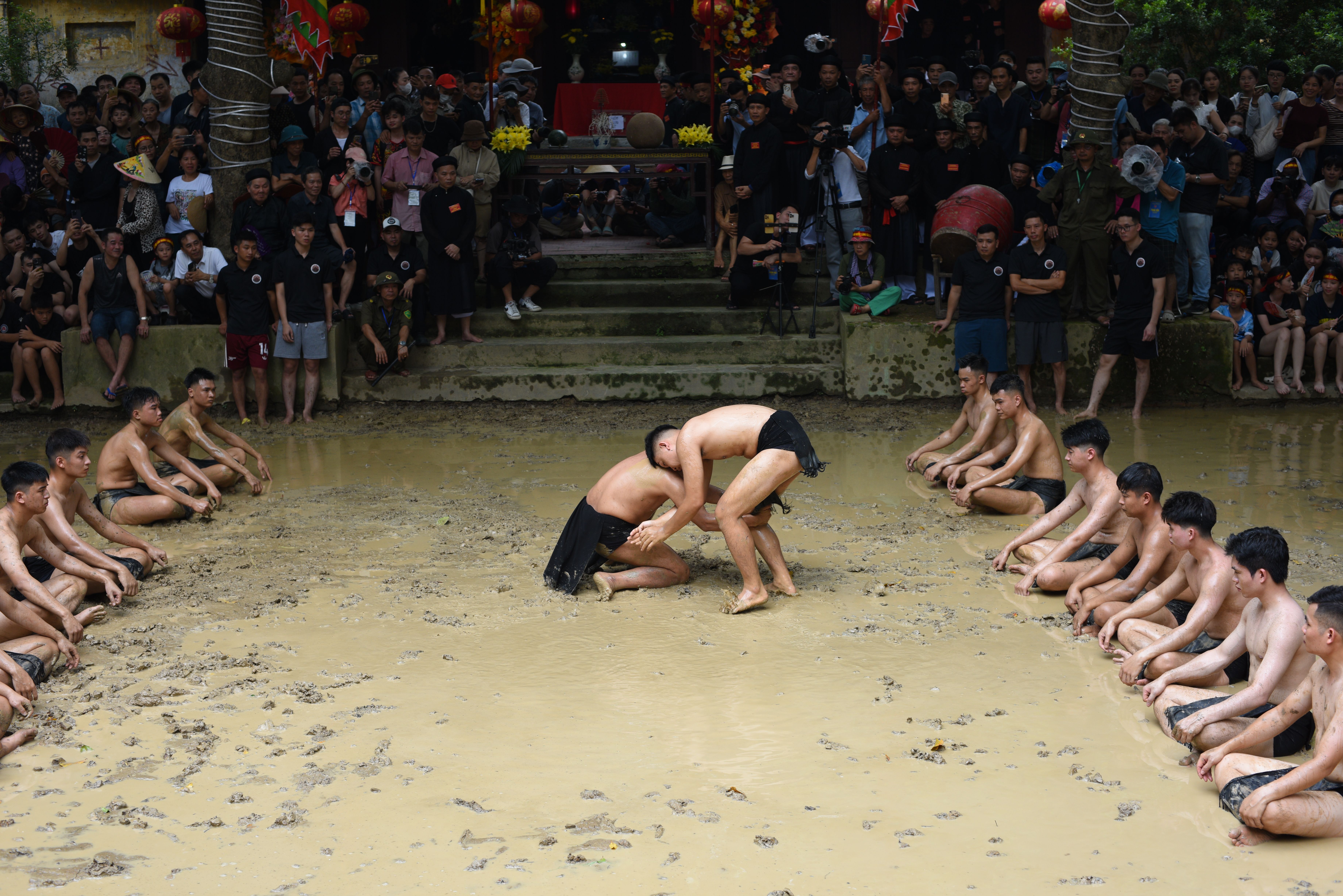 Participants engage in traditional mud wrestling at a vibrant Vietnamese festival.