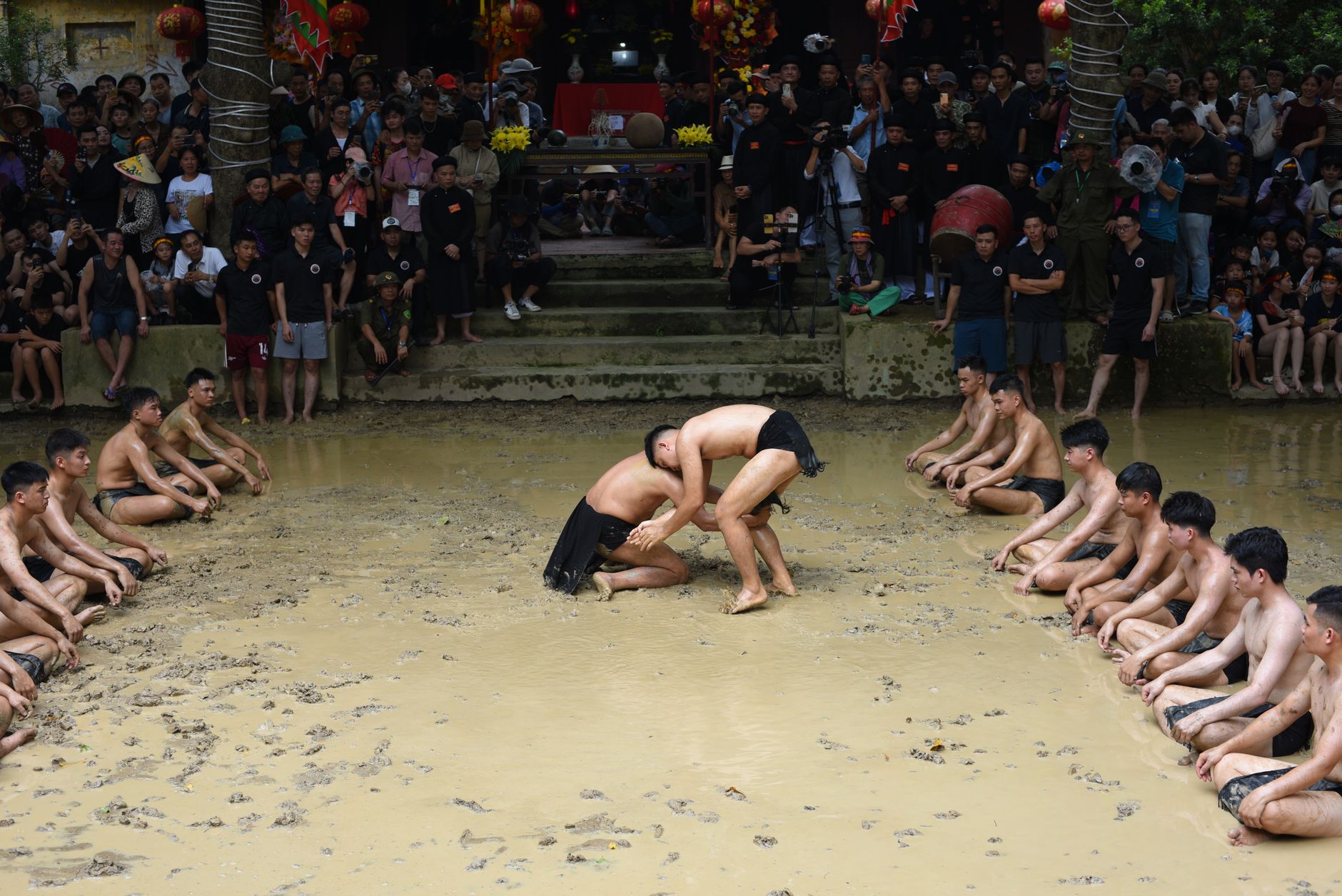 Participants engage in traditional mud wrestling at a vibrant Vietnamese festival.