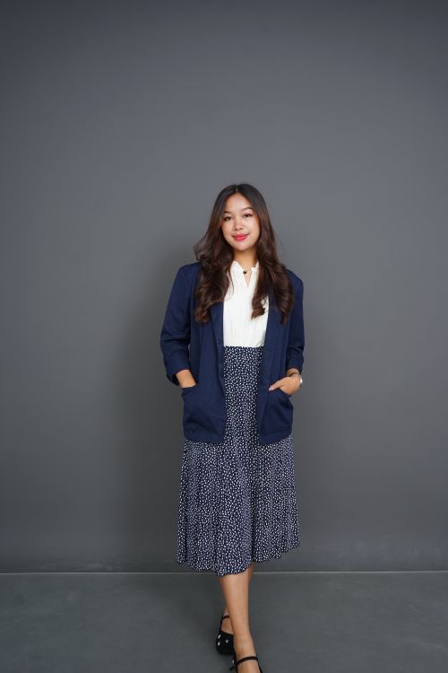 Free Elegant portrait of a confident modern businesswoman in a navy blazer and patterned skirt. Stock Photo