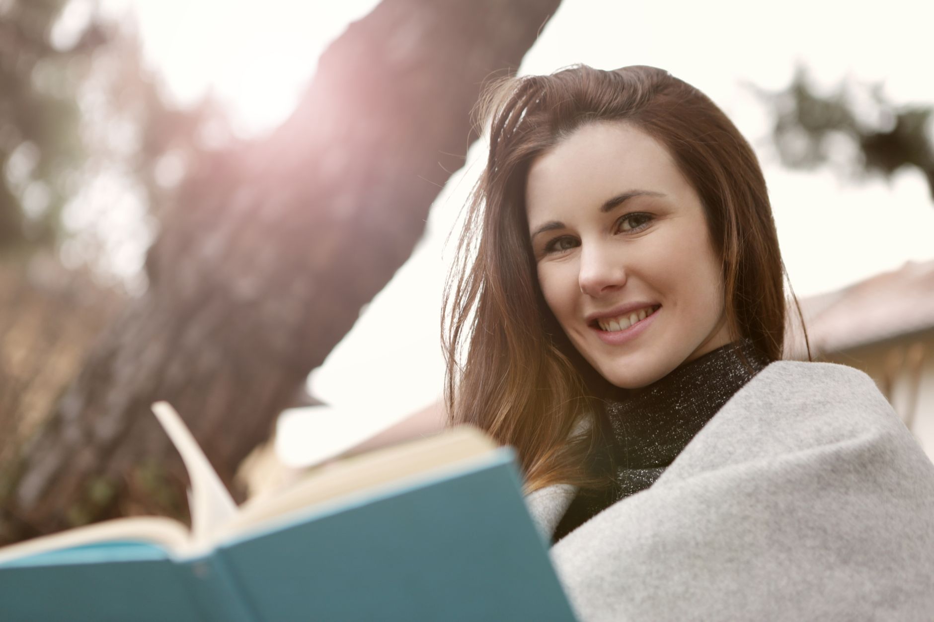A person looking at a book with a satisfied expression