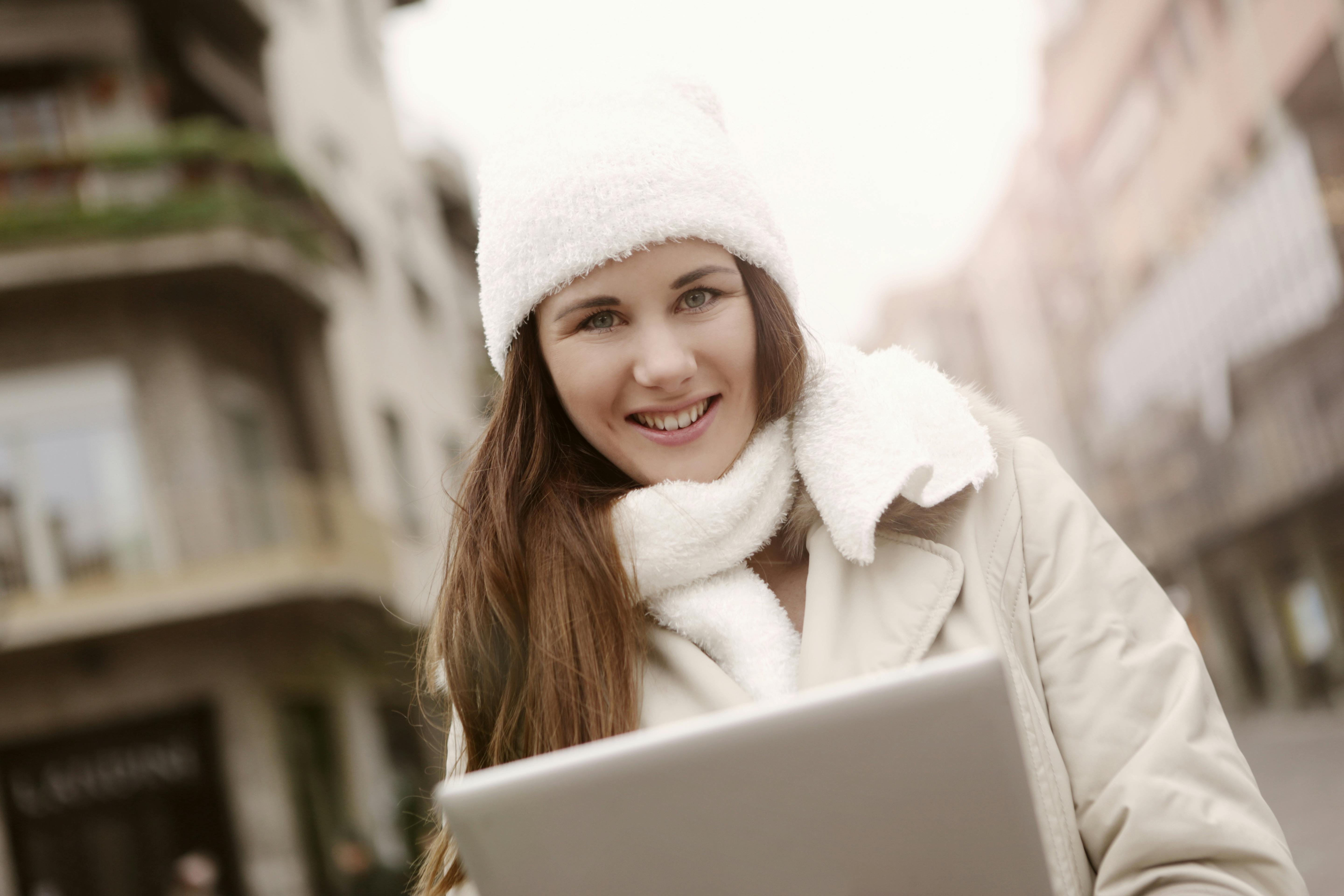 delighted woman using tablet on street