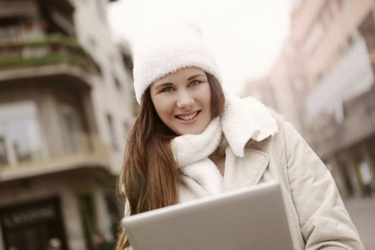 Delighted Woman Using Tablet On Street